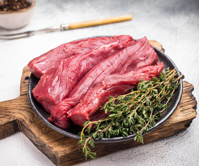 Lammfilet Vier rohe Lammfilets auf einem grauen Teller