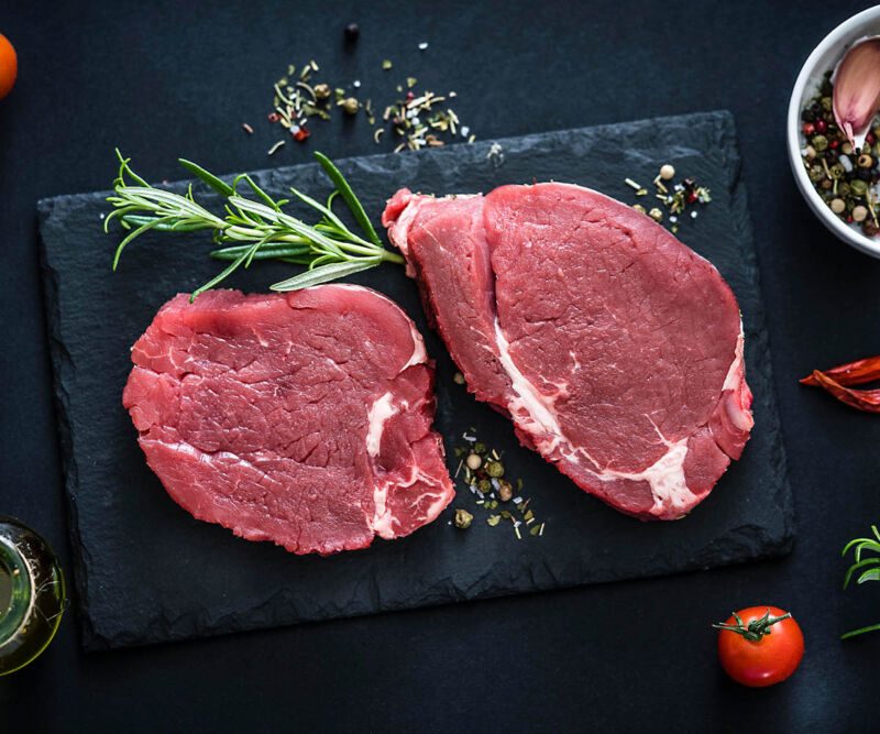 Runderfilet Zwei rohe Rinderfilets auf einer dunklen Schieferplatte